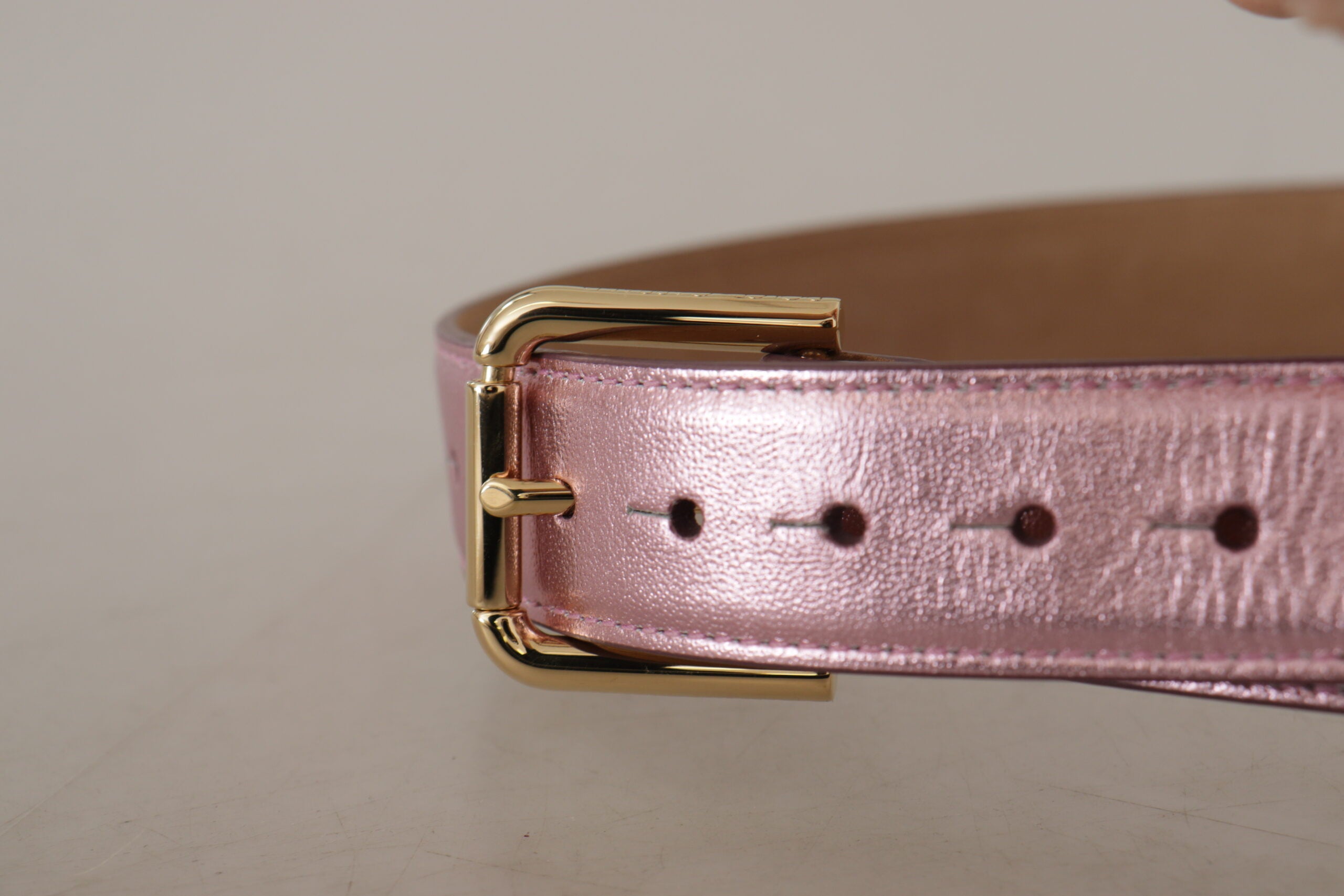 Metallisk rosa, polerad läderbälte med logotyp och metallspänne.