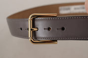 Grå kalvskinnsläderbälte med guldmetallic-logo och spänne