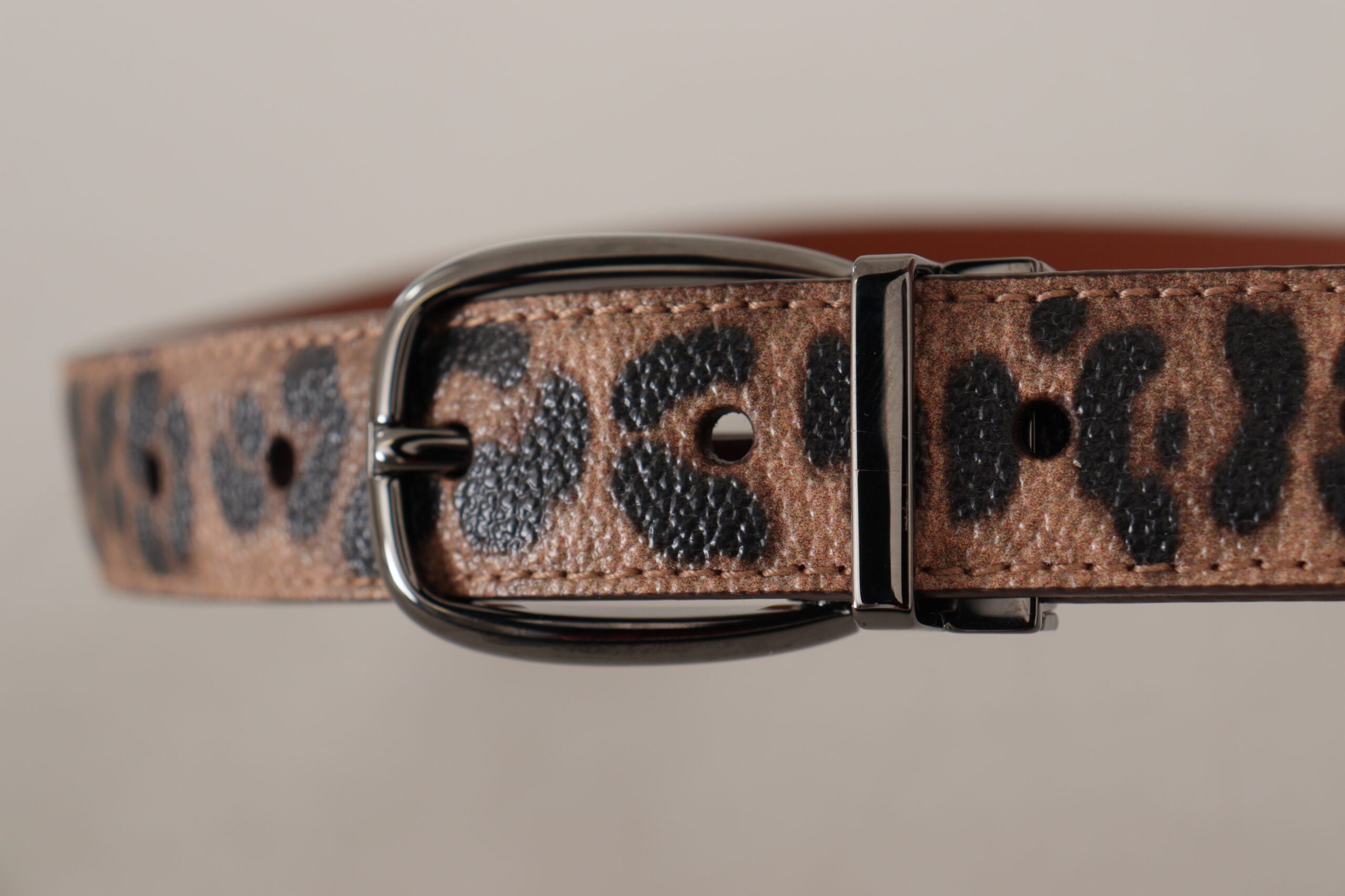 Brun läderbälte med prägling i leopardmönster och spänne.