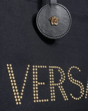 Svart handväska i läder och canvas med logotyp, bärs i handen eller över axeln.