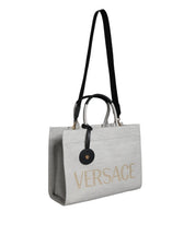 Vit läderhandväska med läderdetaljer och logotyp, med övre handtag och som kan bäras som crossbody-väska.
