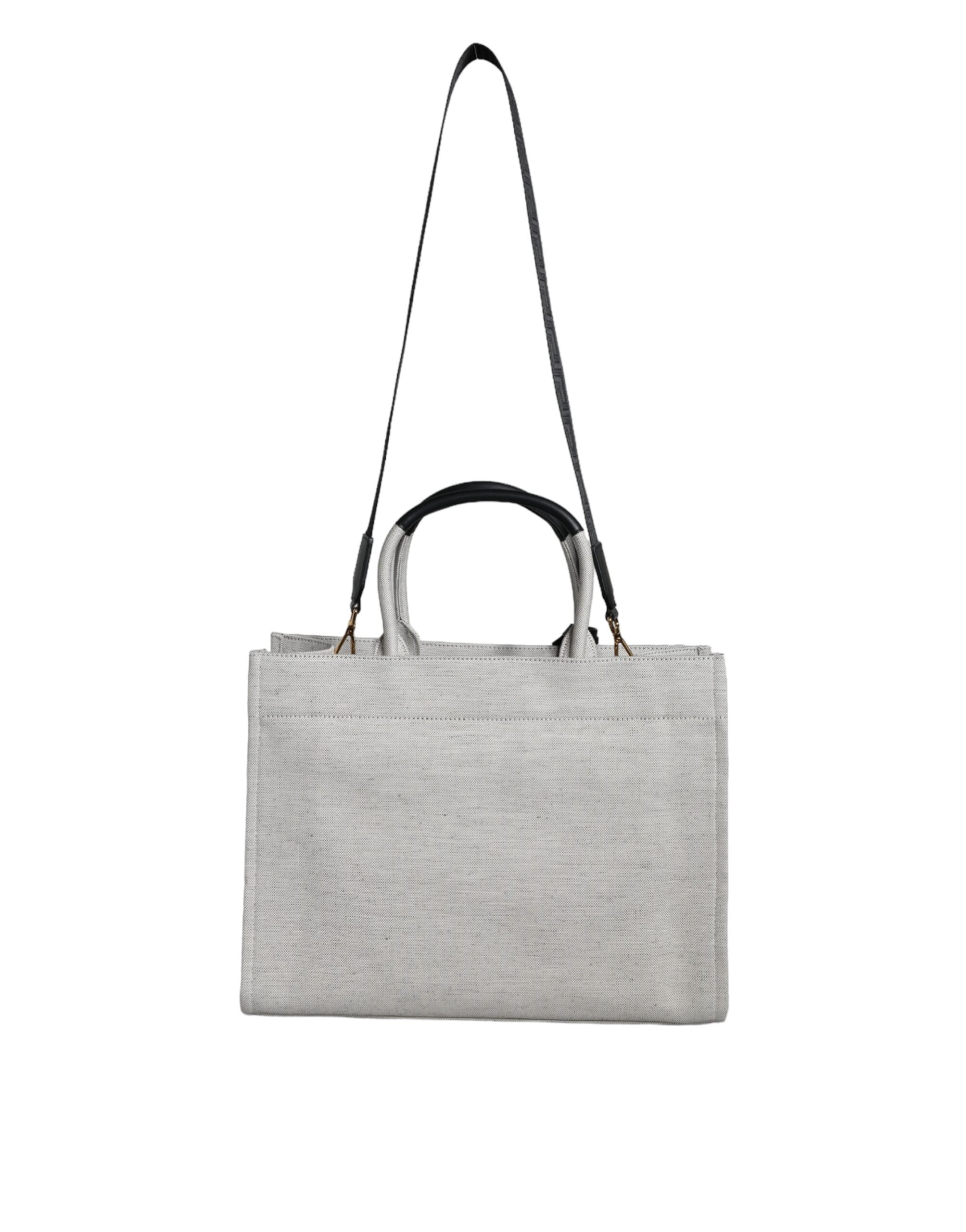 Vit läderhandväska med läderdetaljer och logotyp, med övre handtag och som kan bäras som crossbody-väska.
