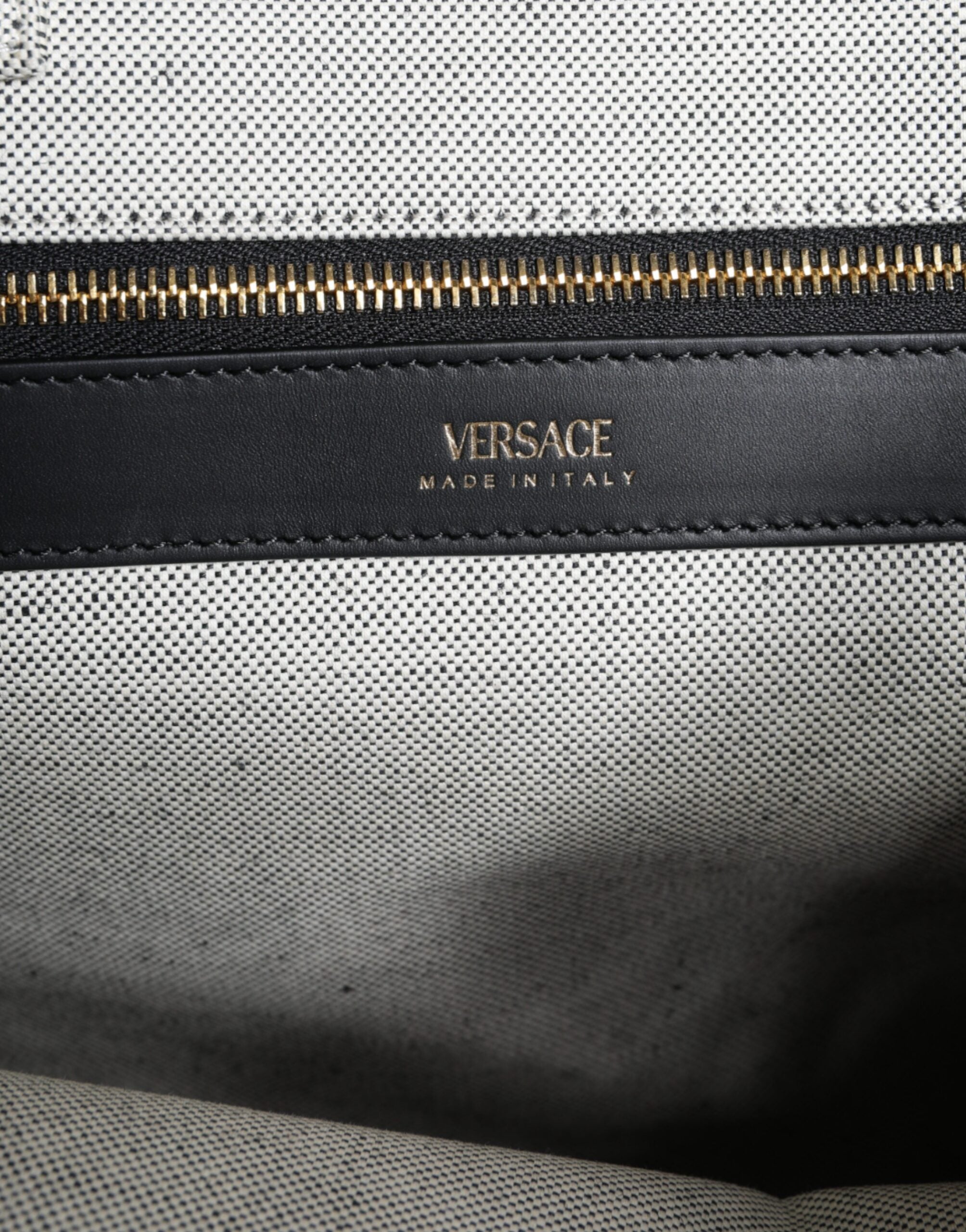 Vit läderhandväska med läderdetaljer och logotyp, med övre handtag och som kan bäras som crossbody-väska.