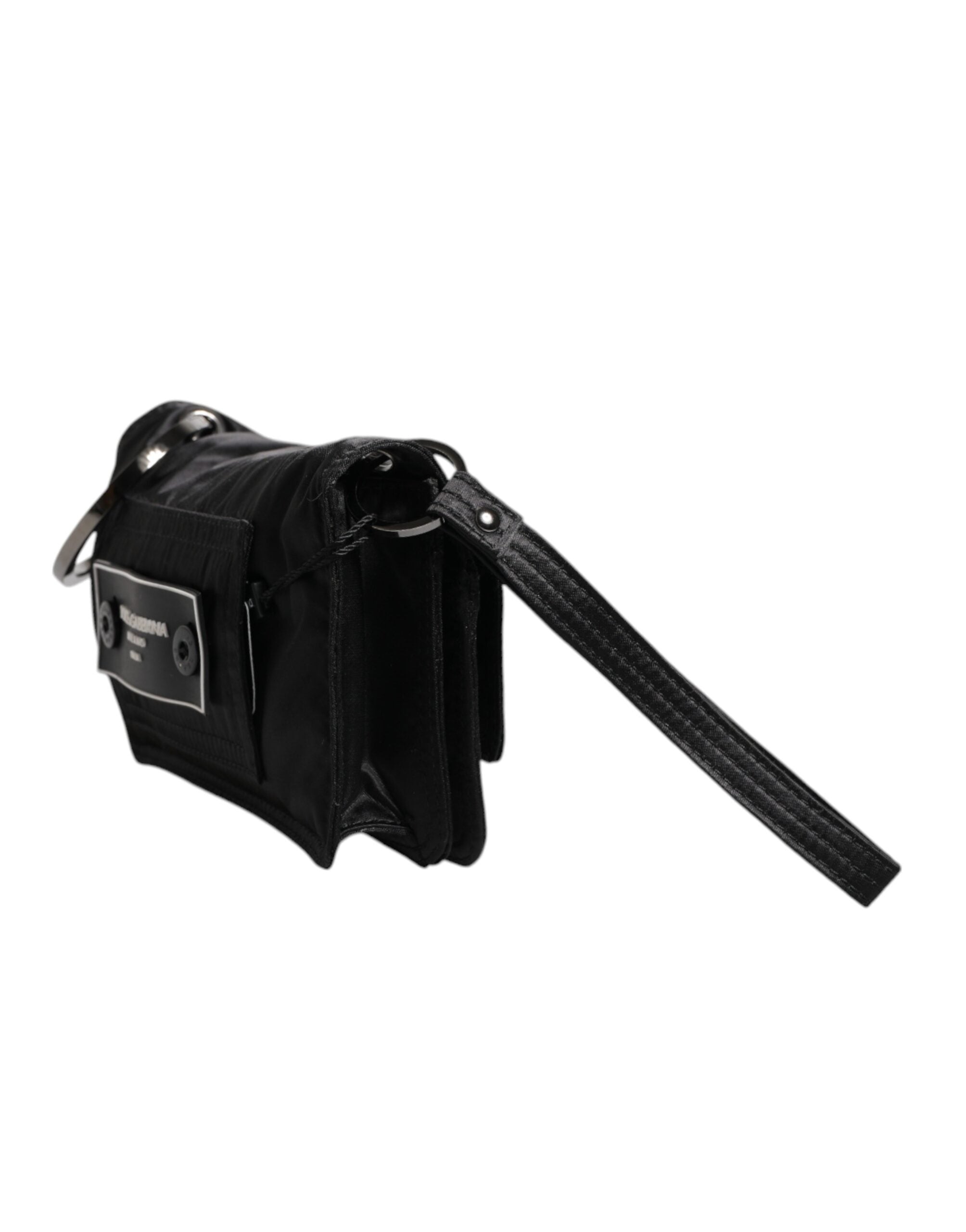 Svart väska i tyg med logotyp, kan bäras som clutch eller crossbody.