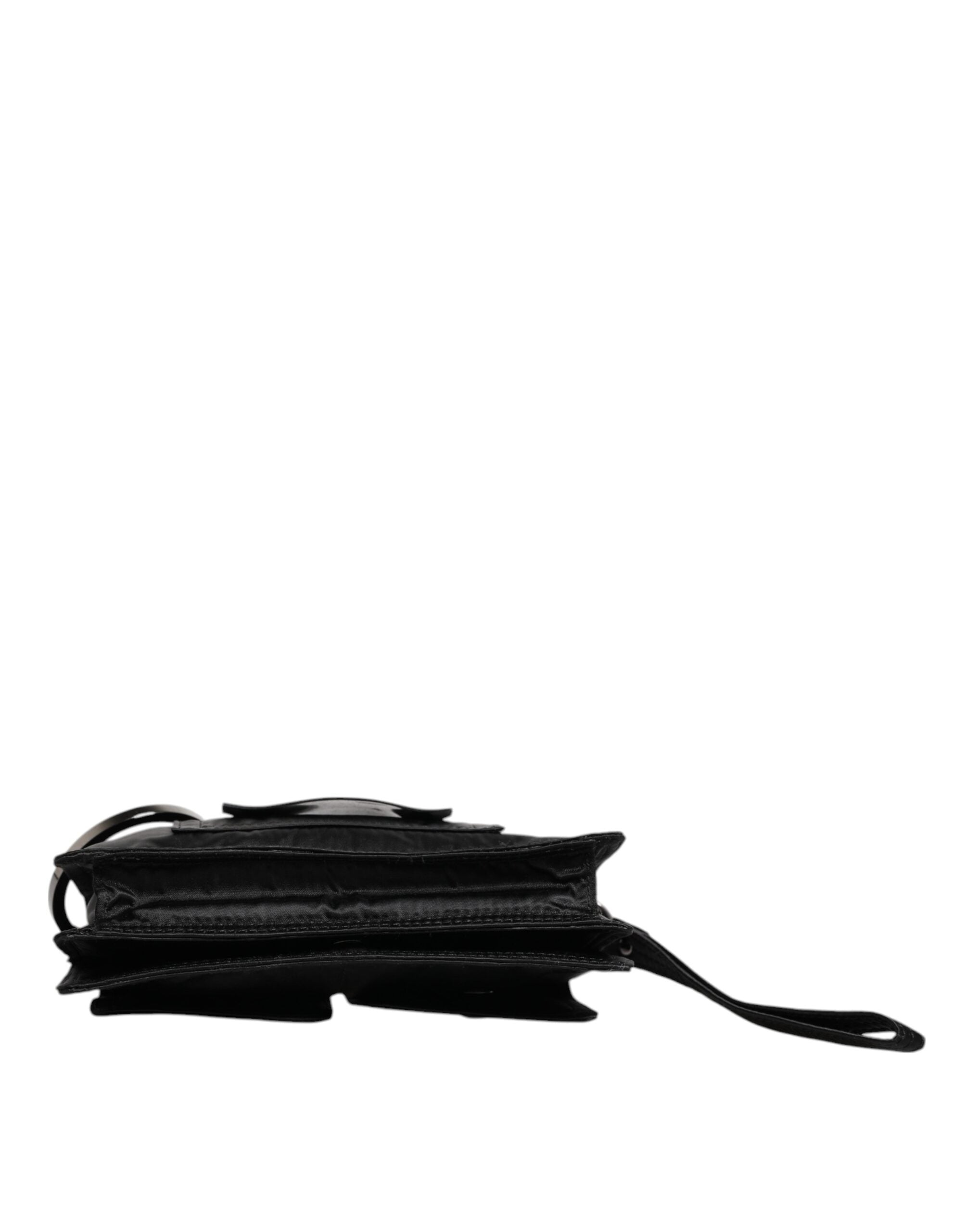 Svart väska i tyg med logotyp, kan bäras som clutch eller crossbody.