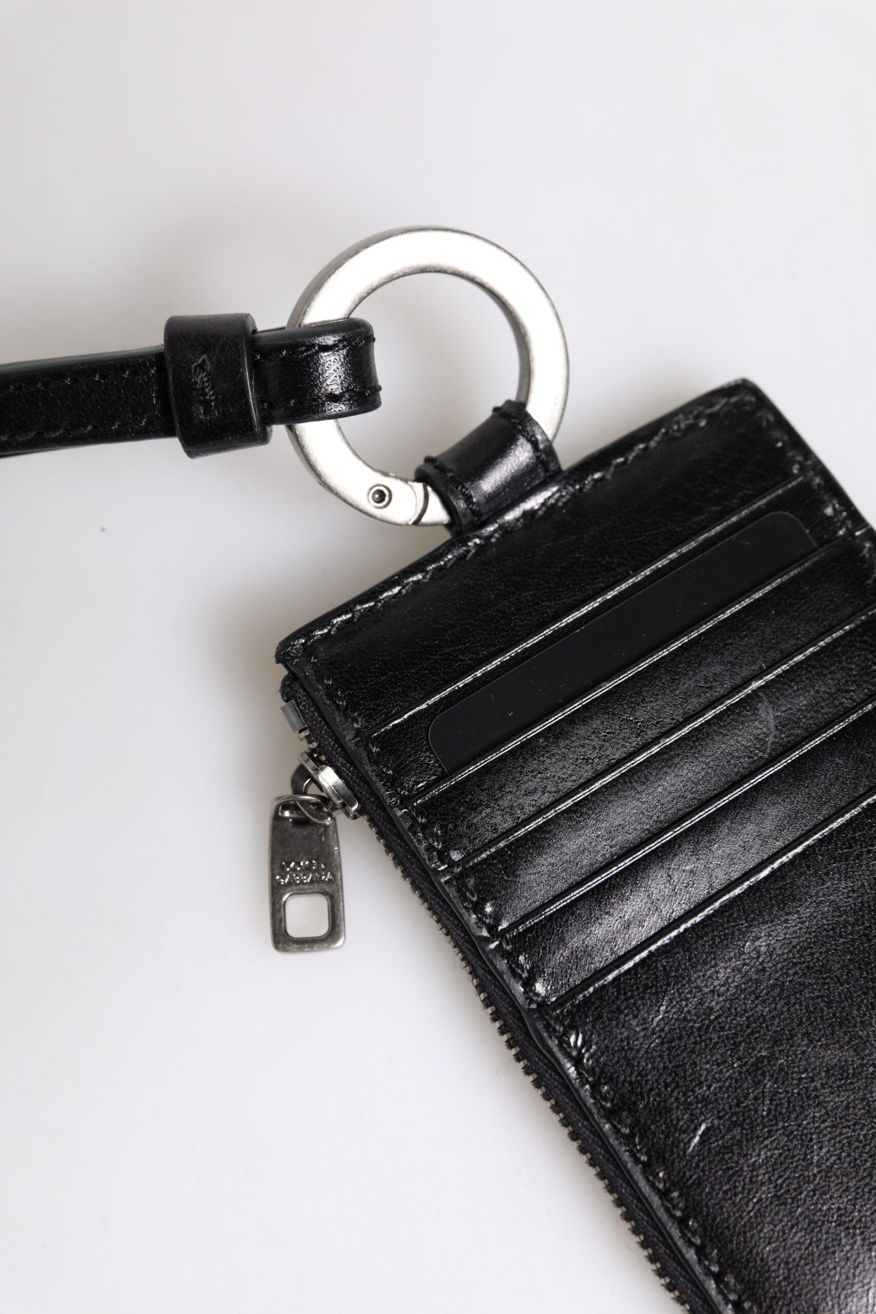 Svart läderplånbok med logotyp och präglat snodd
