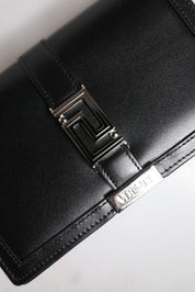 Svart läderhandväska i kalvskinn med kedjeband, för att bära över axeln eller som crossbody-väska.