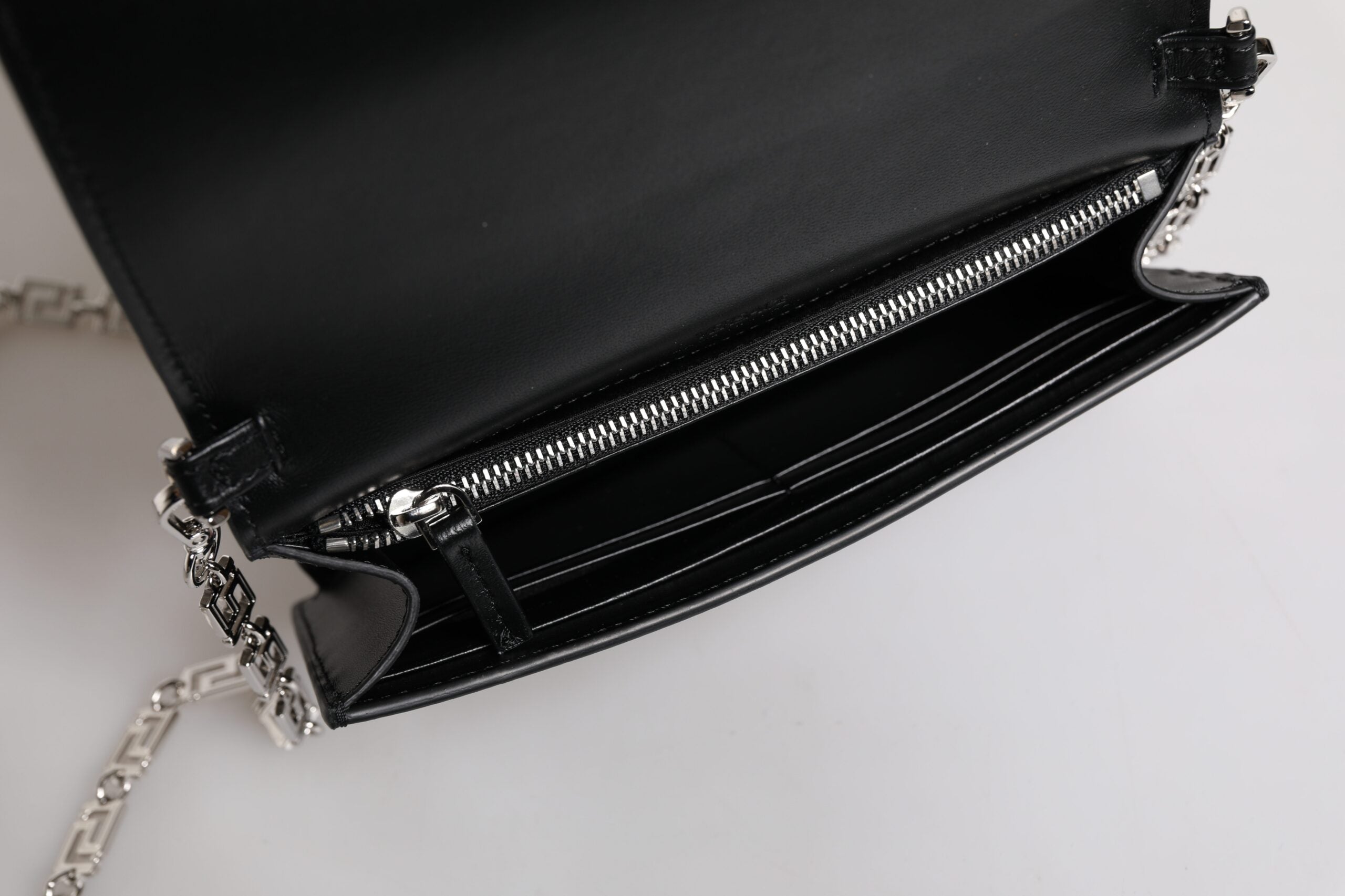 Svart läderhandväska i kalvskinn med kedjeband, för att bära över axeln eller som crossbody-väska.