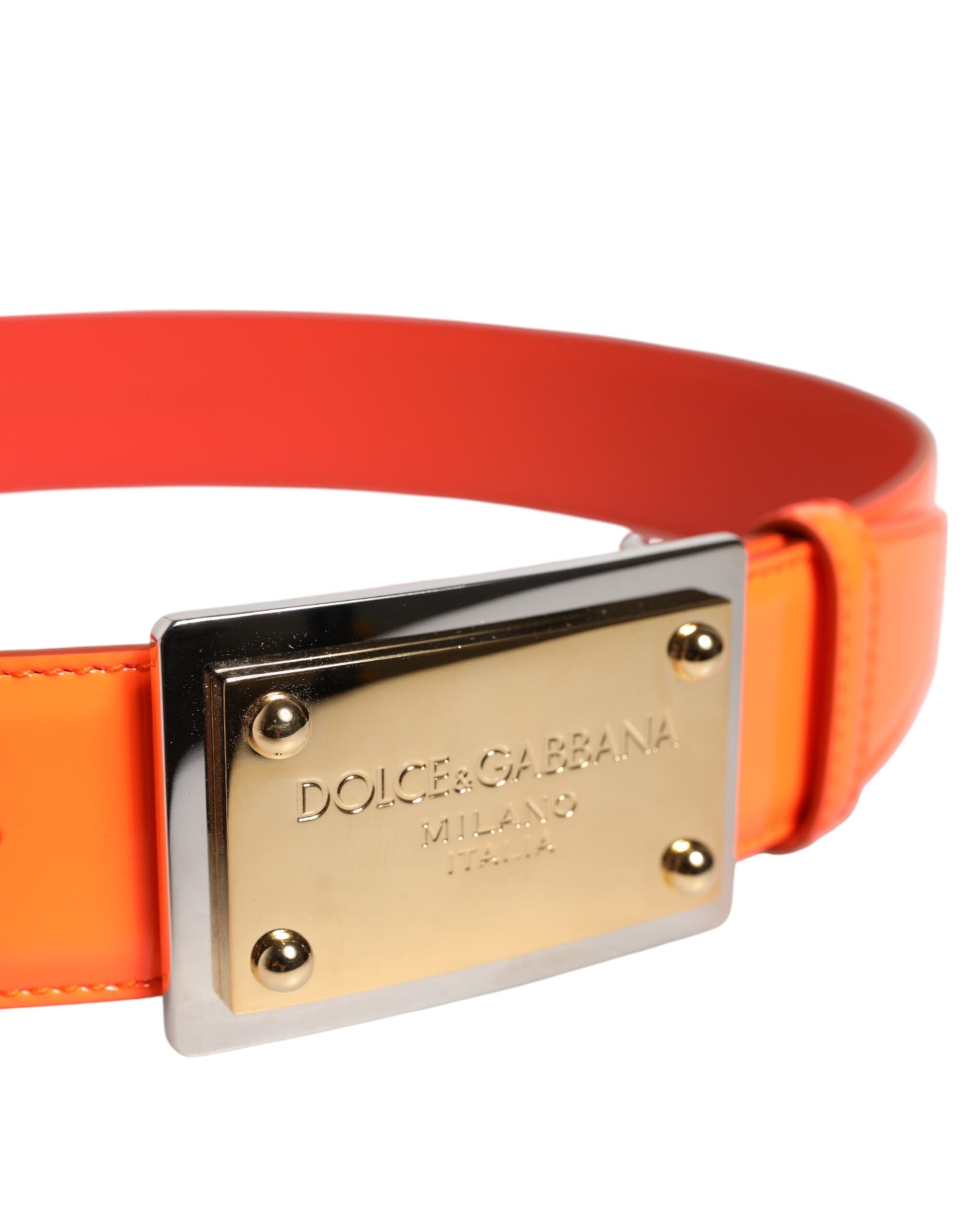 Guldfärgad metallögla med logotyp på orange läderbälte