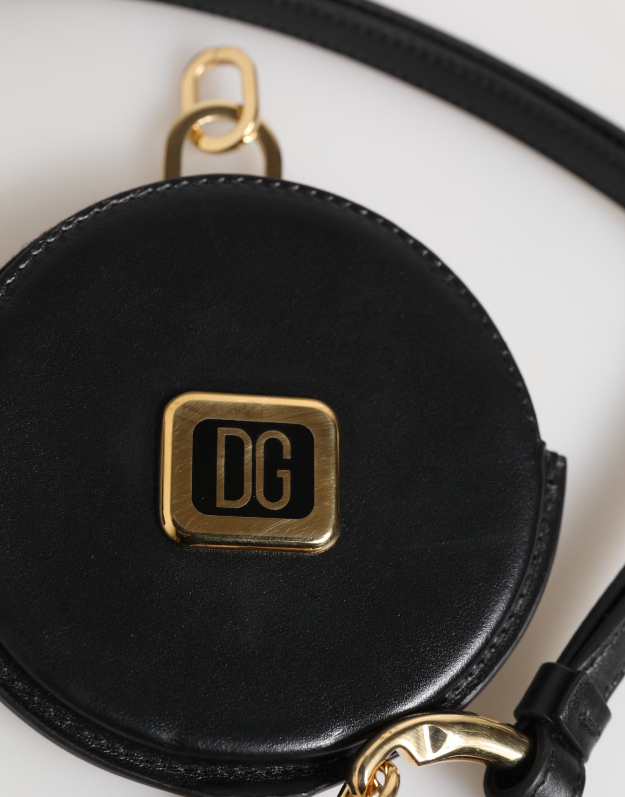 Rund myntväska i svart läder med DG-logotyp och rem