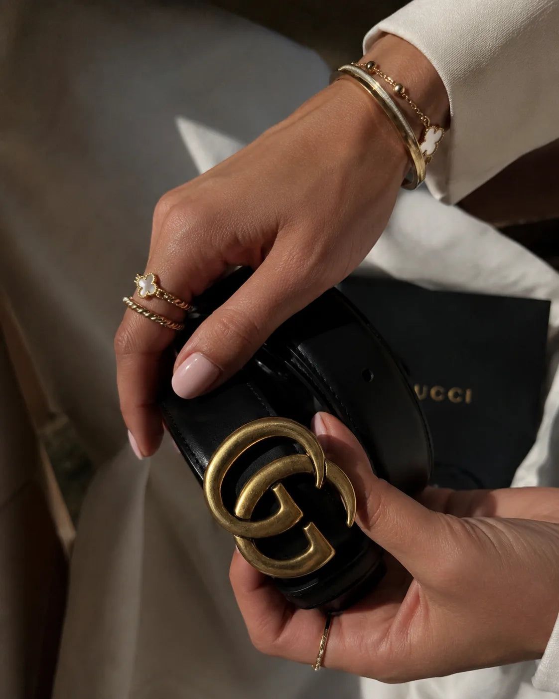 Hand holding a Gucci handbag with a blurred background